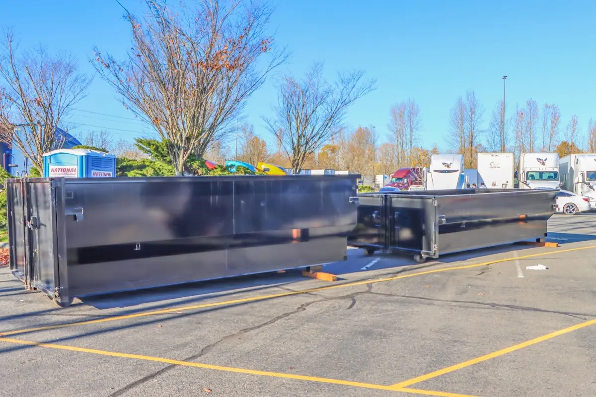 Professional dumpster rental service with roll-off container on residential driveway in East Alton